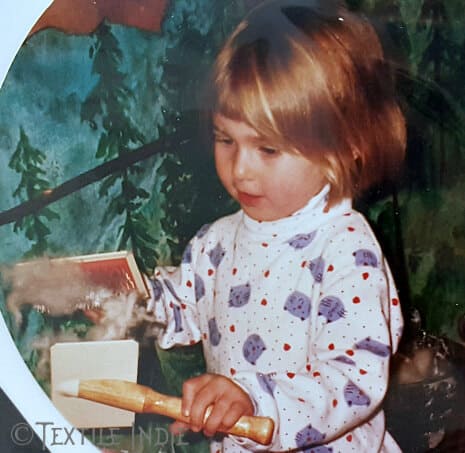 Me as a little one carding wool with hand carders at a children's museum.