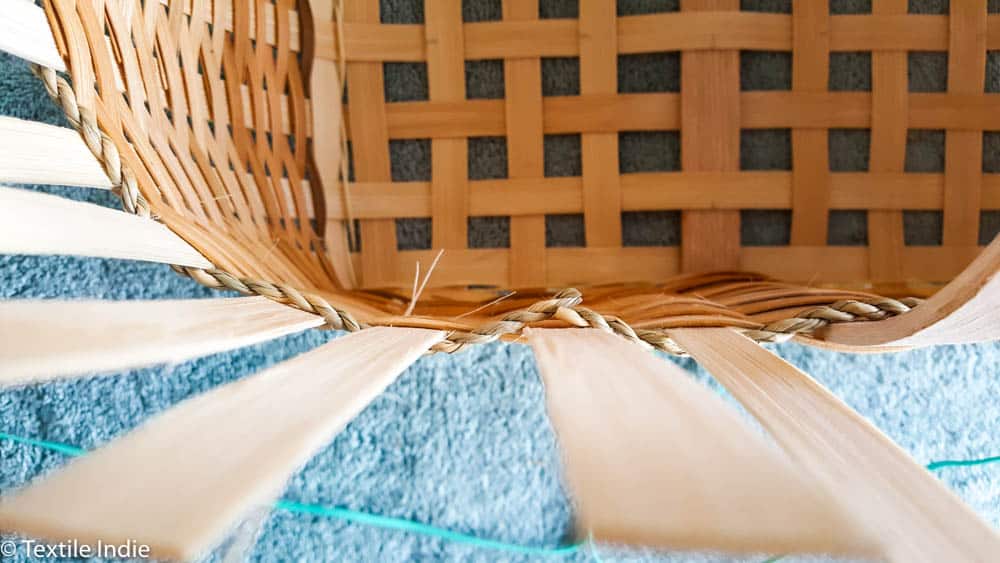 tucking the seagrass behind a stake 