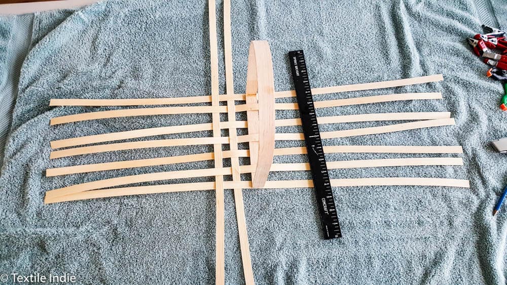 beginning to lay the vertical stakes of a basket base