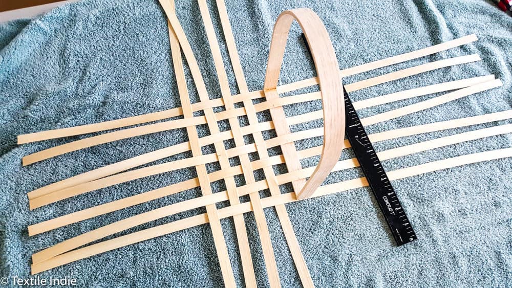 beginning to lay the vertical stakes of a basket base