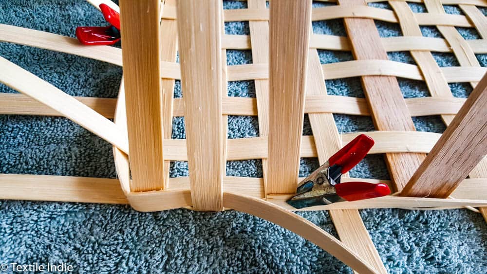 red metal clamps being used on the base of a market basket