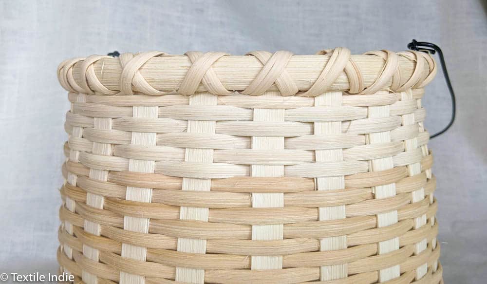 Cross-stitch lashing on the rim of a basket.