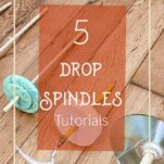 Homemade drop spindles laying on a wood floor.