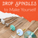 Homemade drop spindles laying on a wood floor.