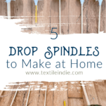 5 different handmade drop spindles laying on a wood floor
