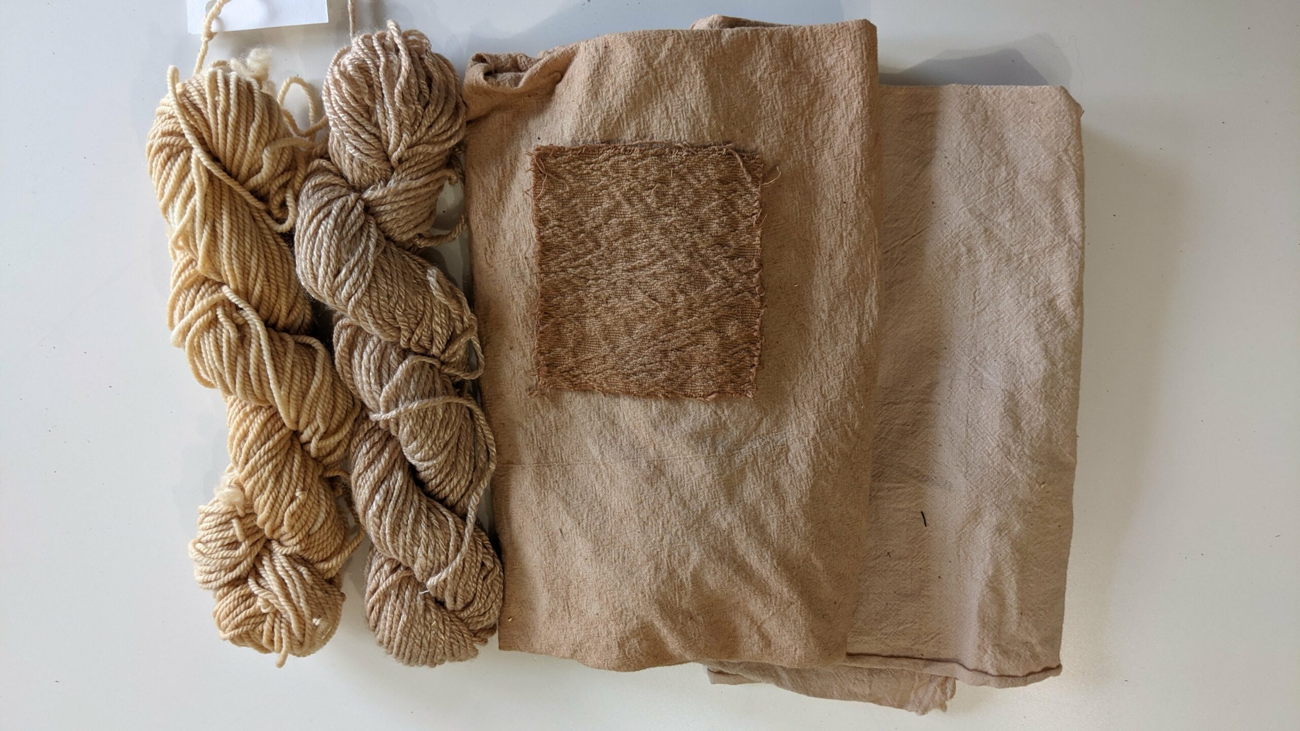 light brown skeins of yarn, and cotton fabrics naturally dyed