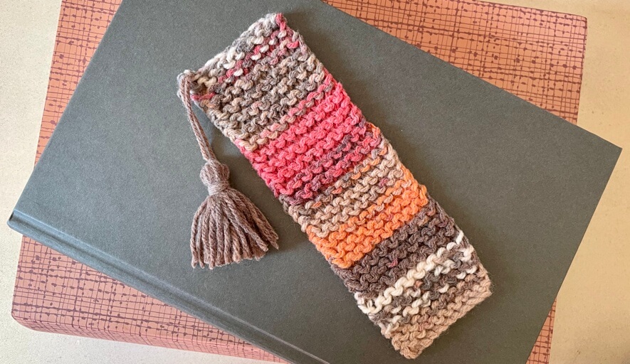 Variegated knit bookmark sitting on a book