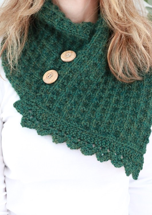 knit forest green cowl with wooden buttons against a white shirt 