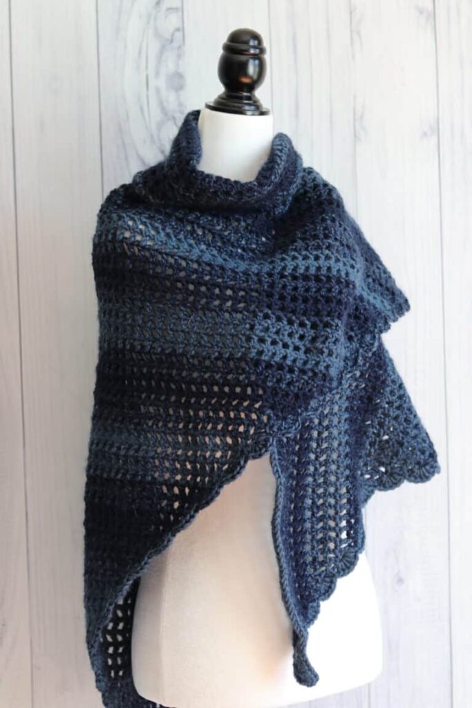 Navy blue triangle shawl draped over a sewing body form