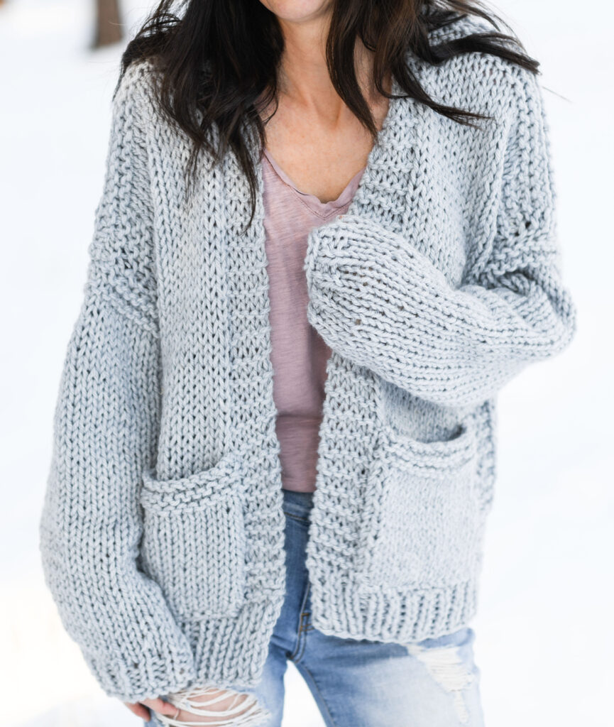 grey knit cardigan on a woman standing in the snow