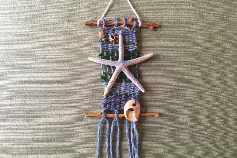 woven yarn wall hanging with a starfish tied on 