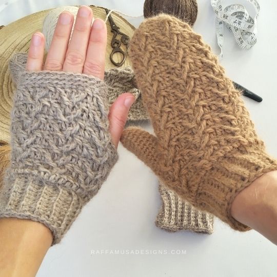 Raffamusa Designs fingerless gloves, a woman wearing one grey and one camel colored mitten. Crochet tools are scattered in the background 