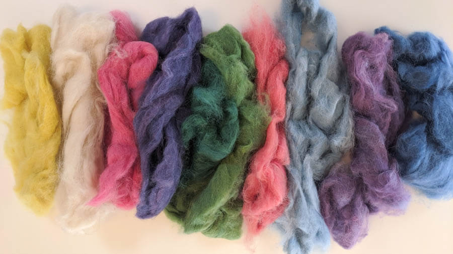 a row of brightly dyed roving ready to spin 