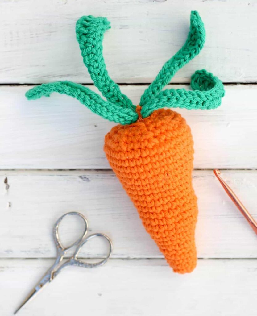 Make and Do Crew carrot crochet in orange with a green top. 