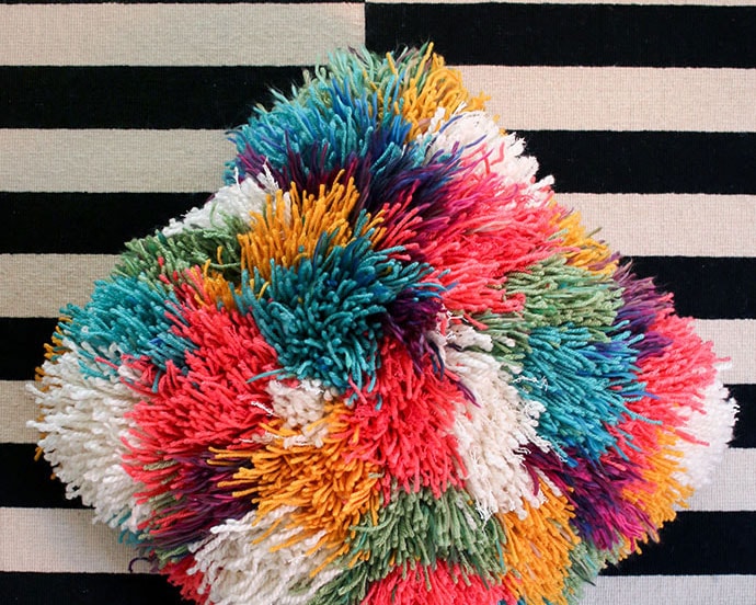 My Poppet brightly colored latch hook yarn pillow against a black and white background 